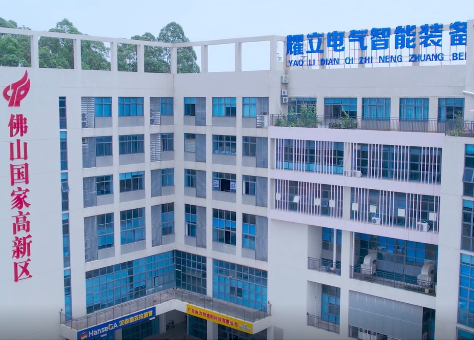 现代化电气制造工厂外景,蓝白相间建筑,大型生产设备,蓝天白云背景